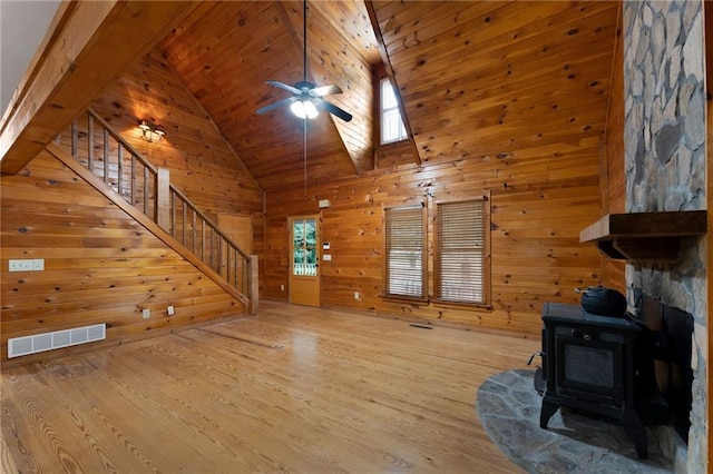 442 Cartecay River Run, Ellijay, GA 30536 - unfurnished living room featuring a wood stove, wood finished floors, stairway, high vaulted ceiling, and wooden walls