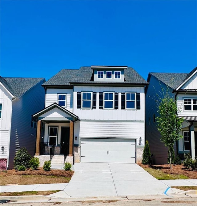 view of front of property with an attached garage, board and batten siding, driveway, and a shingled roof