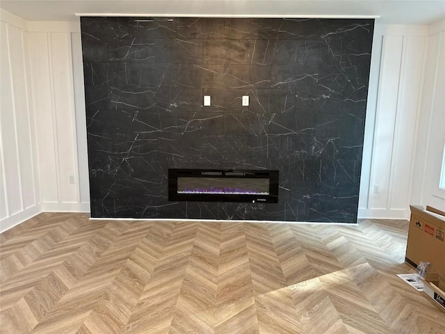 interior details with a glass covered fireplace and a decorative wall