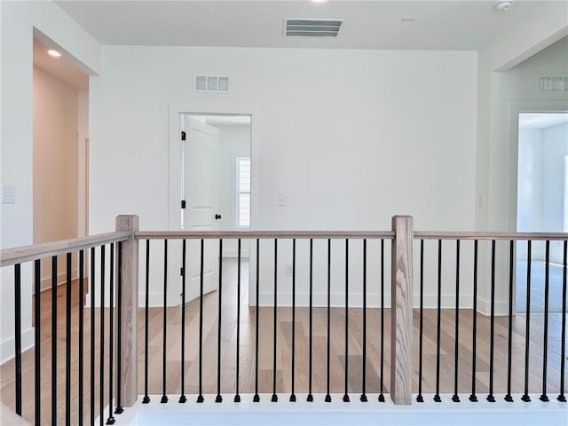 corridor with visible vents and wood finished floors