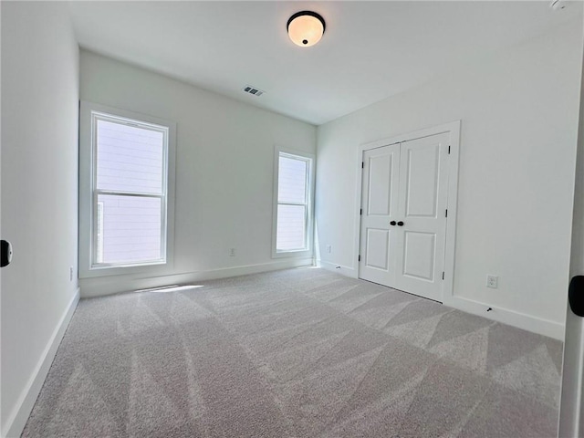 unfurnished bedroom with visible vents, baseboards, and carpet flooring