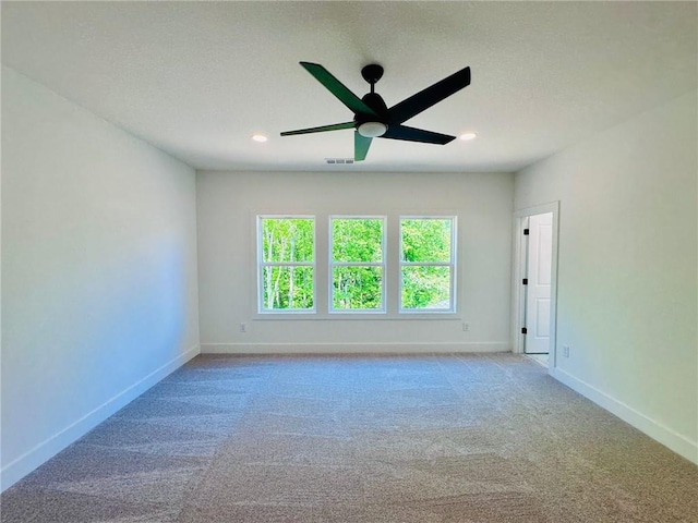 empty room with visible vents, recessed lighting, carpet flooring, baseboards, and ceiling fan