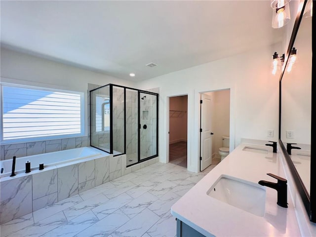 bathroom featuring a bath, marble finish floor, a shower stall, and a sink