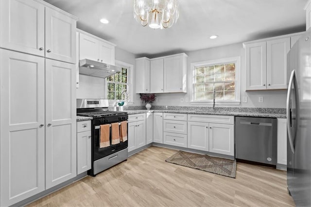 kitchen with white cabinets, under cabinet range hood, stainless steel appliances, and light stone countertops