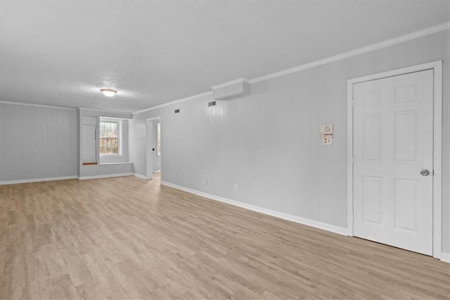 spare room featuring ornamental molding and light wood-style flooring