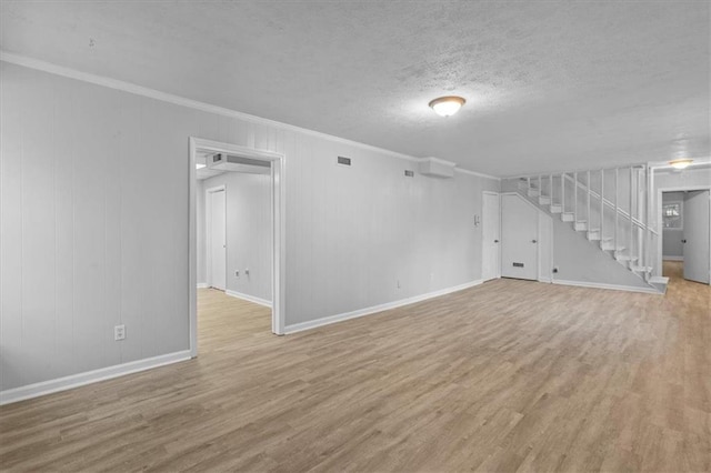 below grade area with ornamental molding, wood finished floors, a textured ceiling, and stairs