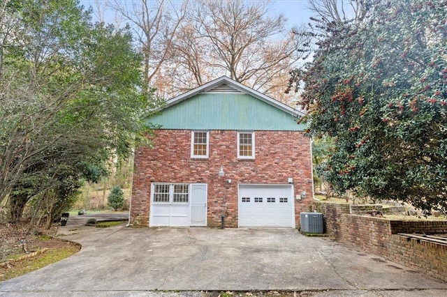 view of home's exterior featuring a garage, central AC, driveway, and brick siding