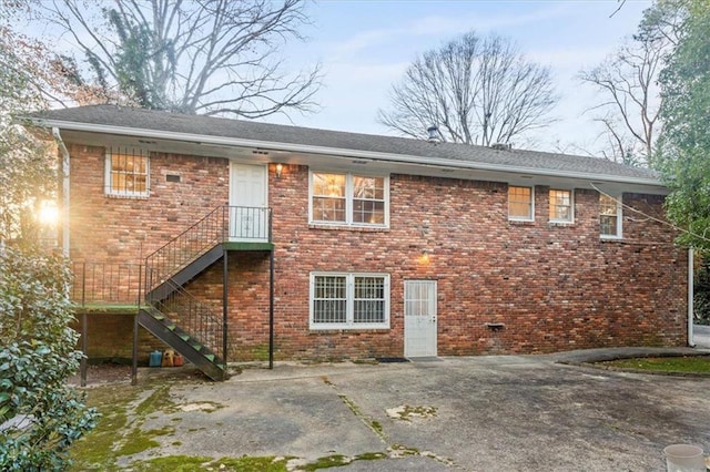 back of property with stairs and brick siding