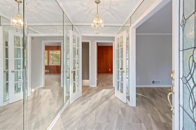 foyer with an inviting chandelier, visible vents, crown molding, and french doors