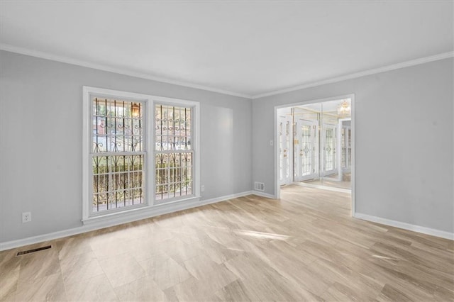 unfurnished room with baseboards, visible vents, and ornamental molding