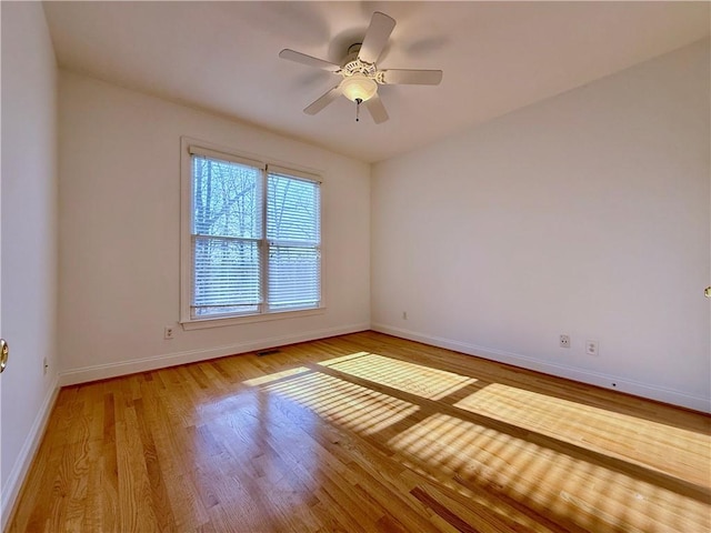 empty room with hardwood / wood-style floors and ceiling fan