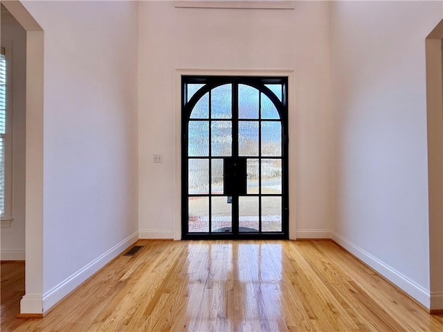 interior space with visible vents, baseboards, light wood-style floors, and french doors