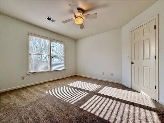 carpeted spare room with ceiling fan