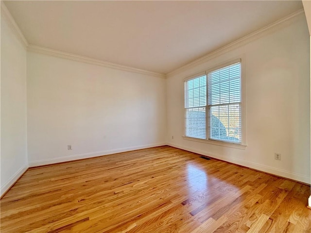 spare room with ornamental molding and light wood-type flooring