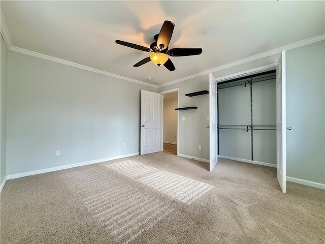 unfurnished bedroom with ceiling fan, light colored carpet, ornamental molding, and a closet