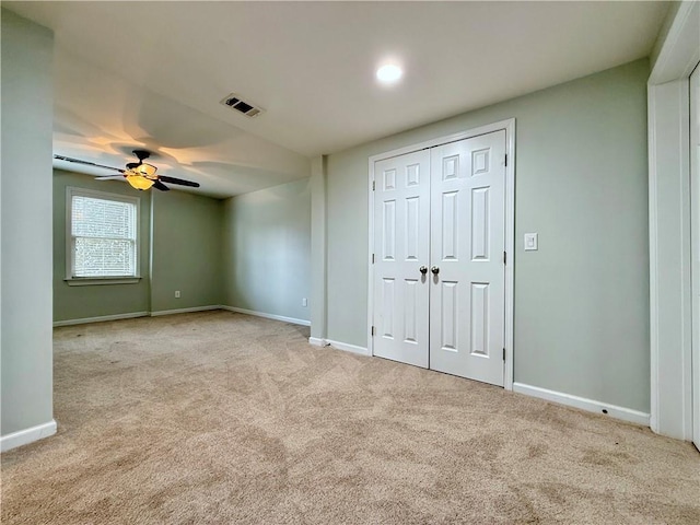 unfurnished bedroom featuring light colored carpet, a closet, and ceiling fan