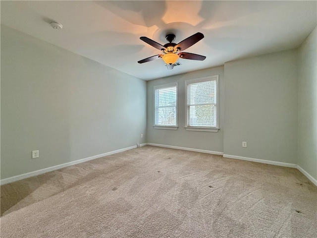 carpeted spare room with ceiling fan