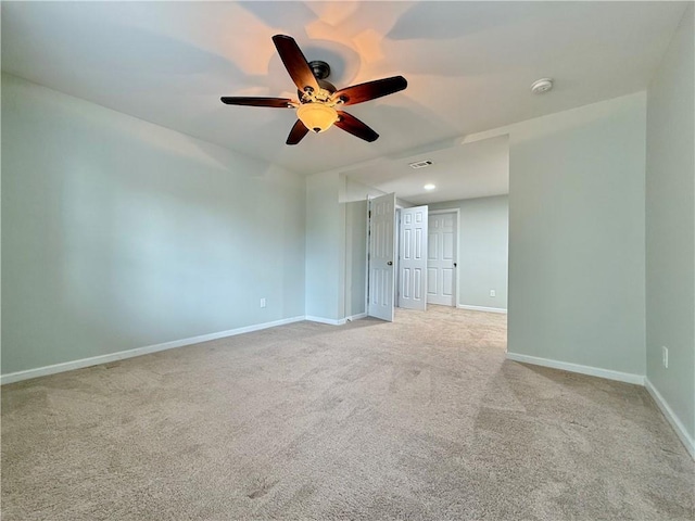 spare room featuring light colored carpet and ceiling fan