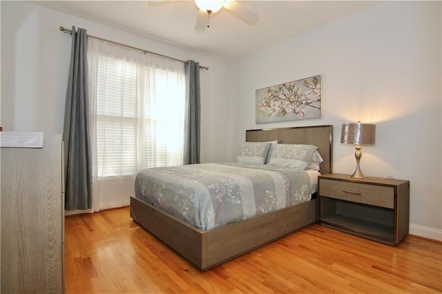 bedroom with hardwood / wood-style flooring, ceiling fan, and multiple windows