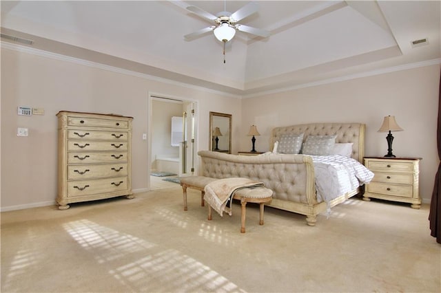 carpeted bedroom with ceiling fan, ornamental molding, a tray ceiling, and ensuite bathroom