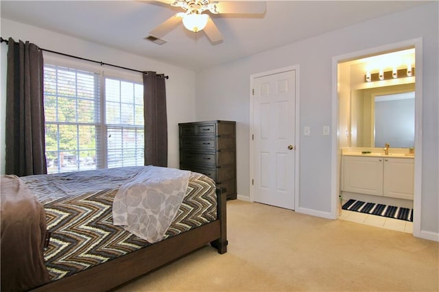 carpeted bedroom with connected bathroom, sink, and ceiling fan