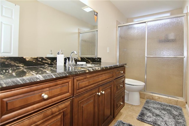 bathroom featuring vanity, tile patterned flooring, a shower with shower door, and toilet