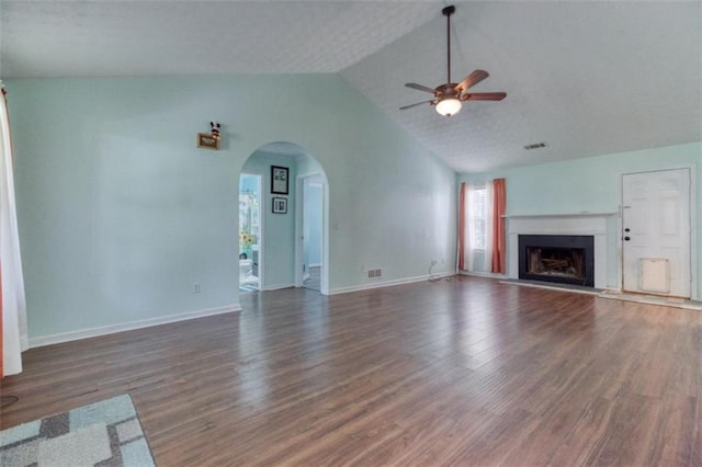 1015 Carriage Way, Loganville, GA 30052 - unfurnished living room featuring ceiling fan, vaulted ceiling, arched walkways, wood finished floors, and a fireplace