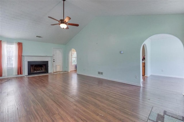 1015 Carriage Way, Loganville, GA 30052 - unfurnished living room with arched walkways, plenty of natural light, ceiling fan, wood finished floors, and high vaulted ceiling