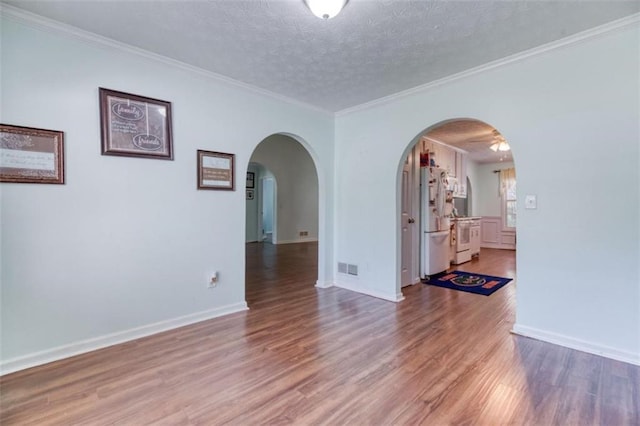 1015 Carriage Way, Loganville, GA 30052 - empty room featuring arched walkways, wood finished floors, ornamental molding, baseboards, and a textured ceiling
