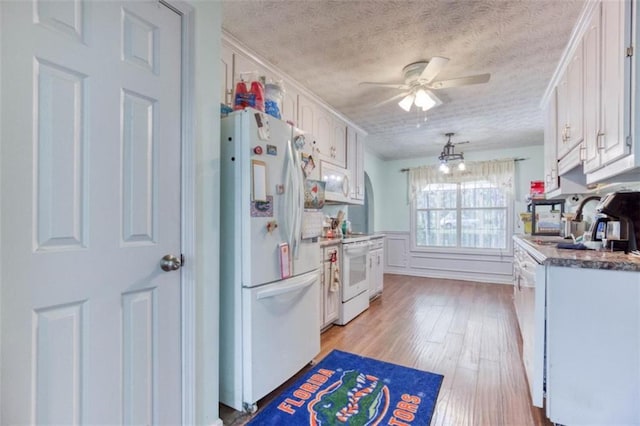 1015 Carriage Way, Loganville, GA 30052 - kitchen with white appliances, white cabinets, a textured ceiling, light wood-style floors, and ceiling fan