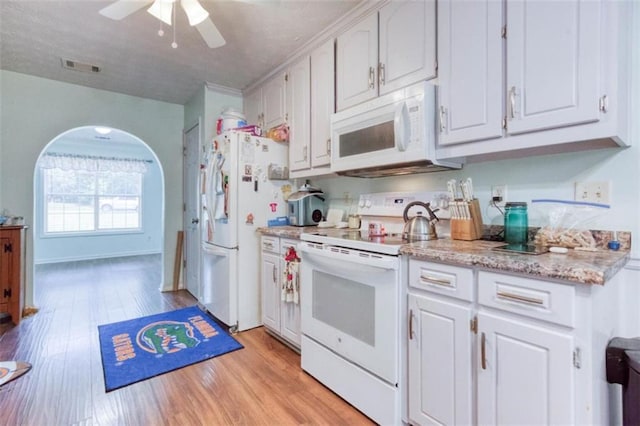 1015 Carriage Way, Loganville, GA 30052 - kitchen featuring white appliances, light wood-style floors, ceiling fan, white cabinets, and light stone counters