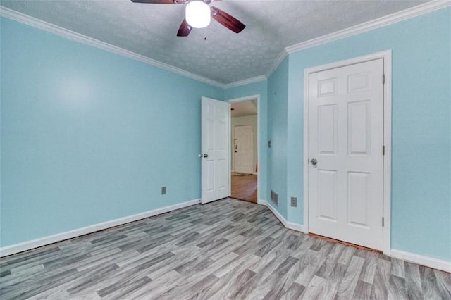 1015 Carriage Way, Loganville, GA 30052 - unfurnished bedroom featuring wood finished floors, a textured ceiling, baseboards, a ceiling fan, and ornamental molding