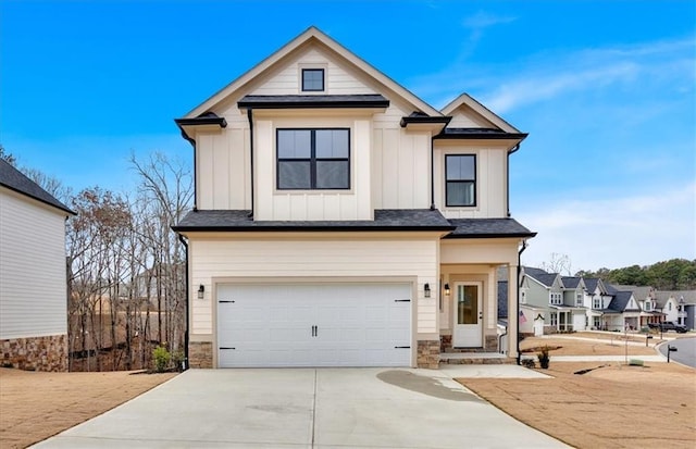 view of front facade featuring board and batten siding, stone siding, driveway, and an attached garage