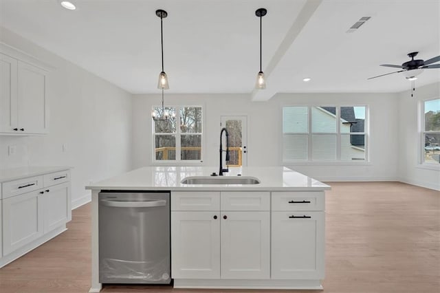 kitchen with a sink, light wood-style flooring, dishwasher, and hanging light fixtures