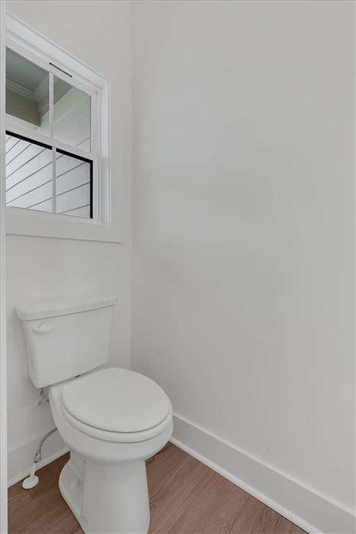 bathroom featuring toilet, baseboards, and wood finished floors