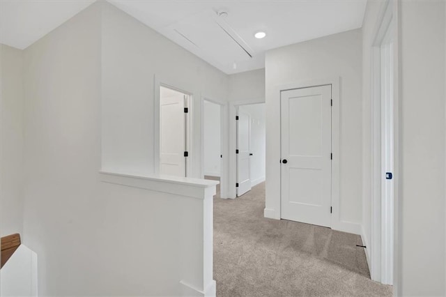 hallway with carpet floors, baseboards, and an upstairs landing