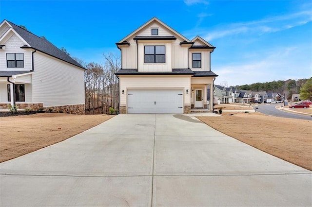 view of front of house featuring an attached garage, stone siding, board and batten siding, and concrete driveway