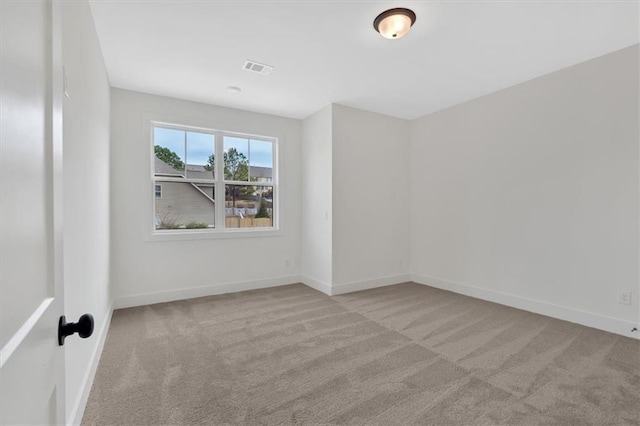 unfurnished room with carpet, visible vents, and baseboards