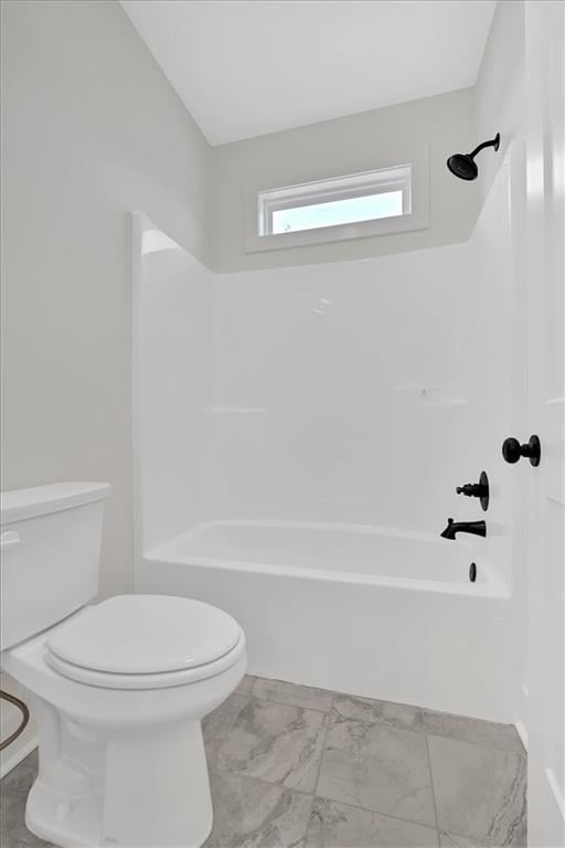 full bath with marble finish floor, shower / bath combination, and toilet