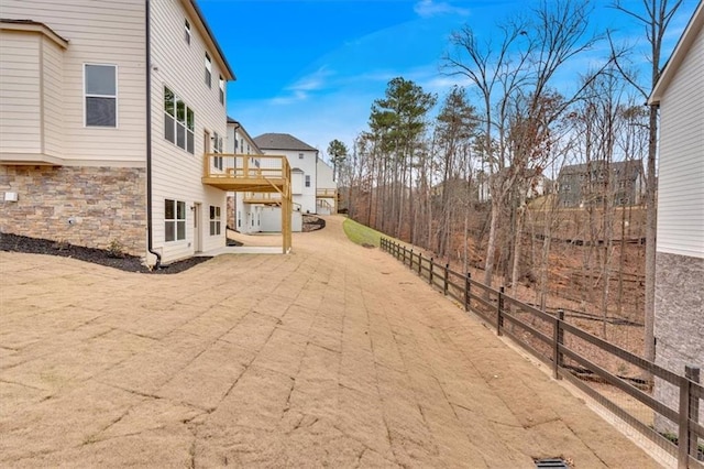 view of yard featuring fence and a balcony