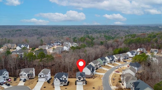 drone / aerial view featuring a residential view and a forest view