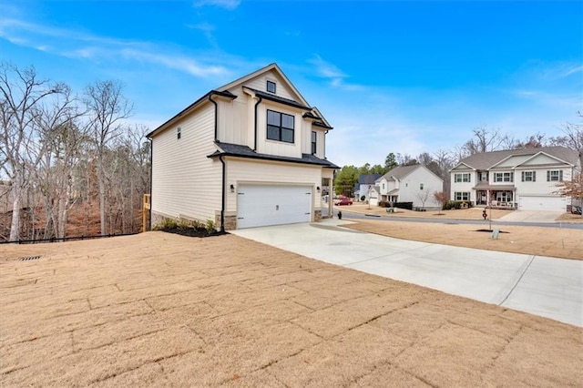 view of front of property featuring a garage, a residential view, and driveway