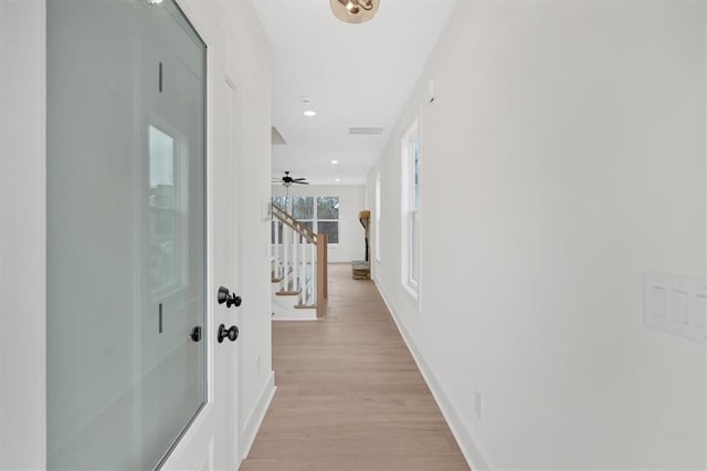 corridor featuring recessed lighting, visible vents, baseboards, stairway, and light wood finished floors