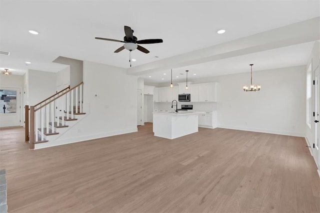 unfurnished living room featuring stairs, recessed lighting, light wood-style flooring, baseboards, and ceiling fan with notable chandelier