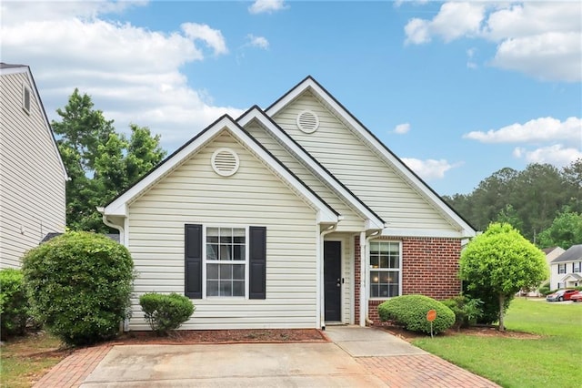 view of front facade featuring brick siding and a front yard