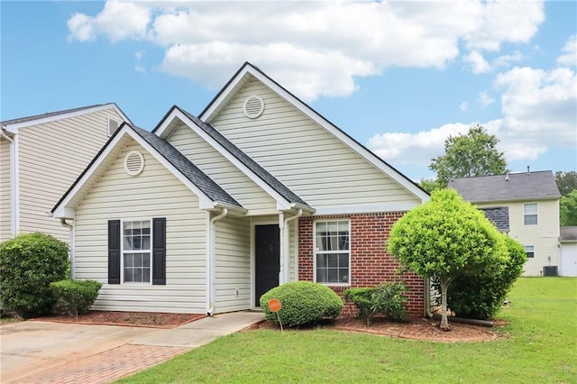 view of front of home featuring brick siding, a front lawn, and cooling unit