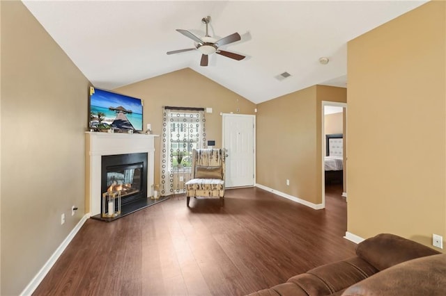 living room featuring a ceiling fan, visible vents, a glass covered fireplace, and wood finished floors