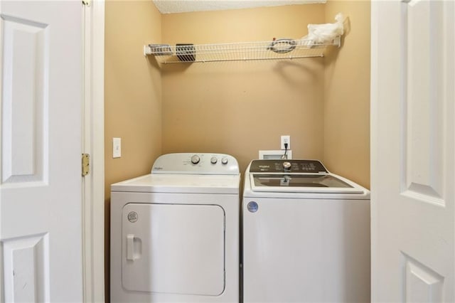 clothes washing area with washer and dryer and laundry area