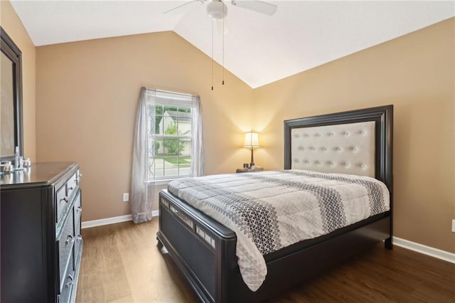 bedroom featuring baseboards, a ceiling fan, wood finished floors, and lofted ceiling