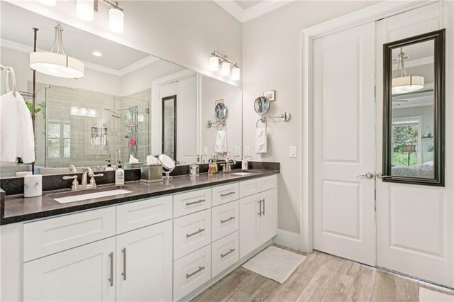 bathroom featuring walk in shower, ornamental molding, vanity, and hardwood / wood-style floors